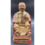 An antique Chinese carved wooden figure of a seated dignitary or emperor.