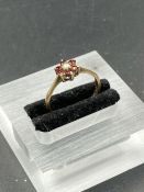 A 9ct gold ring with garnets and a central pearl.(1.4g)