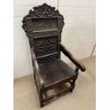 A carved oak wainscot chair with heavy carved back plank seat and turned legs