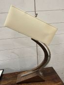 A table lamp with curving stand with chrome details
