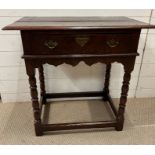 An oak 18th Century single drawer side table with brass handles on turned legs