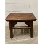 An oak stool with pierced cut outs to sides (H37cm W37cm D20cm)