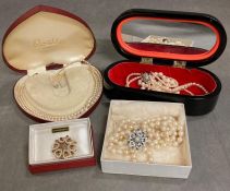 A selection of four pearl necklaces, various settings and clasps and a single brooch