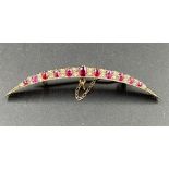 A Diamond and ruby crescent brooch in a gold setting