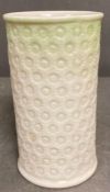 A small Belleek white and green vase