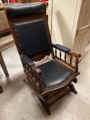 A rocking chair with studded blue leather seat