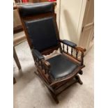 A rocking chair with studded blue leather seat