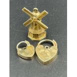 9ct gold items, two heart shaped fasteners and a windmill charm (Approximate Total weight 5g)