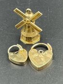 9ct gold items, two heart shaped fasteners and a windmill charm (Approximate Total weight 5g)