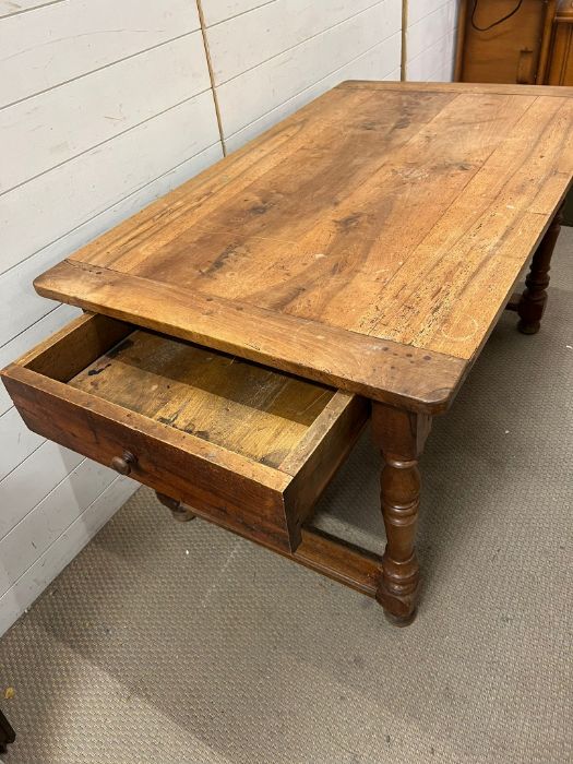 A farmhouse table with drawer to one end on turned legs and centre stretcher (H74cm W130cm D78cm) - Image 2 of 3