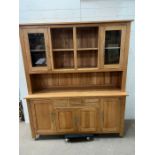 An oak dresser with glazed cabinets and drawers and cupboards under (H182cm W162cm D45cm)