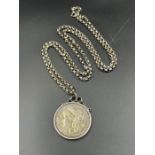 A 1900 US silver dollar on a substantial silver chain and mount