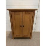 A two door oak cabinet by Furniture Land (H90cm W65cm D40cm)