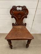 A Victorian hall chair with scroll moulded back plank seat raised on turned legs