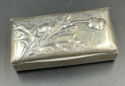 A silver pill box with a thistle motif, hallmarked for London 1903,