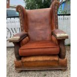 A throne style armchair with oak side supports and replace seat cushions