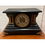 A wooden mantle clock with pillar column sides, this clock has a slate hook