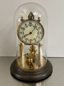 An anniversary clock made in Germany under glass dome and brass base
