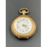 A small ladies pocket watch, marked 585, on case, machine tooled decoration of a lady to back of