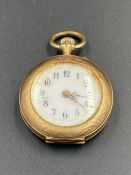 A small ladies pocket watch, marked 585, on case, machine tooled decoration of a lady to back of