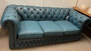 An aqua Chesterfield sofa with stud details to arms