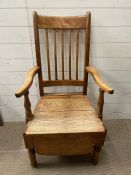 A pine high back farmhouse chair with solid seat and wooden skirt to base