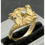 A 9ct gold ring, horse themed ring, a diamond set between two horse heads. Size K1/2 and approximate