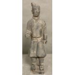 A clay figure in the style of a Chinese terracotta warrior, signed to base.