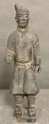 A clay figure in the style of a Chinese terracotta warrior, signed to base.