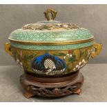 A Cloisonné lidded pot on a wooden stand