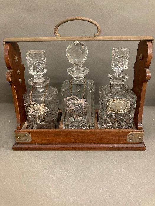 An oak lockable tantalus with three lead crystal decanters