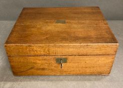 A light oak writing box with inkwell with brass lid and a selection of quells