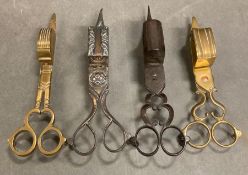 A selection of four various candle trimmers.