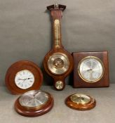 A selection of four contemporary barometers and a clock