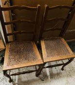 A pair of yew ladder back chairs with wicker seats and scroll cabriole legs