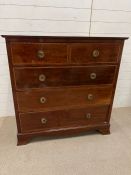 A mahogany chest of drawers with brass ring handles on bracket feet