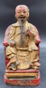 An antique Chinese carved wooden figure of a seated dignitary or emperor.