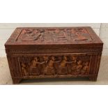 A small hardwood chest with carved ceremonial scenes to all sides