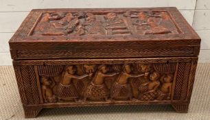 A small hardwood chest with carved ceremonial scenes to all sides