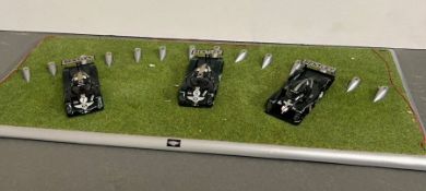 A Bentley display stand and three Bentley diecast racing cars.