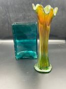 A green carnival glass vase and a blue square vase