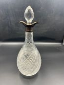 A glass decanter with silver rim