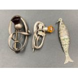 Three items of silver jewellery by Charles Horner to include an articulated fish and two Celtic