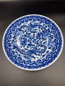 A blue and white "Dragon" dish, painted in deep underglaze, blue with dragon, clasping at foliage on