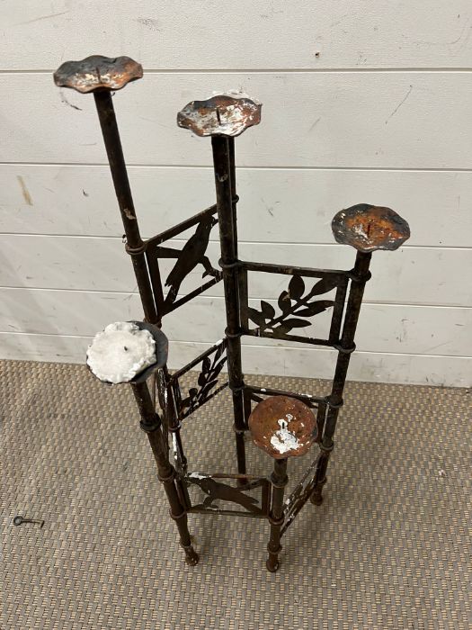 An outdoor garden metal candle holder with leaf and bird design