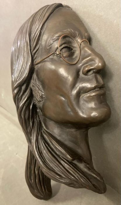 A bronze bust or wall hanging of John Lennon in profile, signed by the artist Jeanne Rynhart