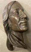 A bronze bust or wall hanging of John Lennon in profile, signed by the artist Jeanne Rynhart