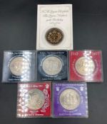 A collection of six collectable Crown coins to include Silver Jubilee, Queen Mothers 90th