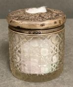 A cut glass jar with a silver hallmarked lid