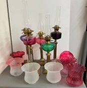 Five brass oil lamps with cranberry glass and clear glass shades (H54cm0